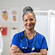 A woman in blue scrubs with a stethoscope around her neck.
