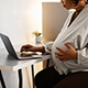 A pregnant woman using a laptop.