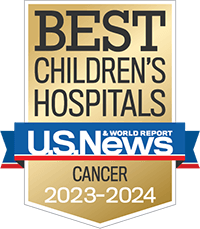 A gold badge with a red and blue ribbon holding the U.S. News and World Report logo recognizing best children's hospitals for cancer care.