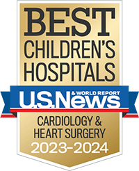 A gold badge with a red and blue ribbon holding the U.S. News and World Report logo recognizing best children's hospitals for cardiology and heart surgery.