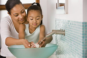 Mother and daughter washing hands.