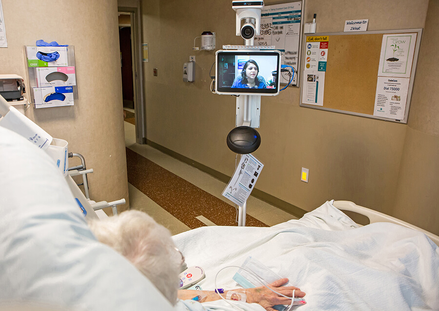 An elderly woman speaking with a physician on a video screen.