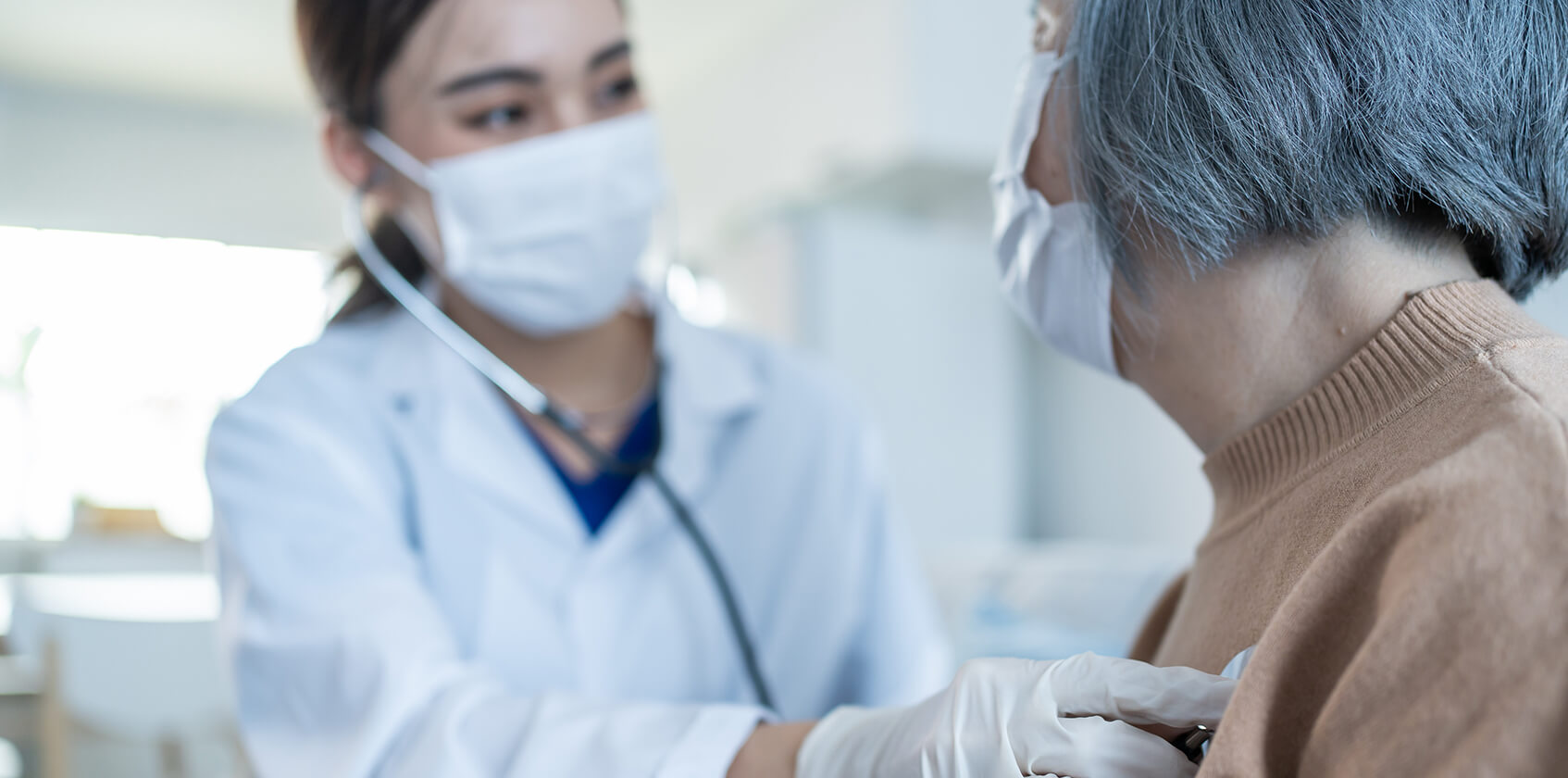Provider listening to a patient's heart with stethoscope. 