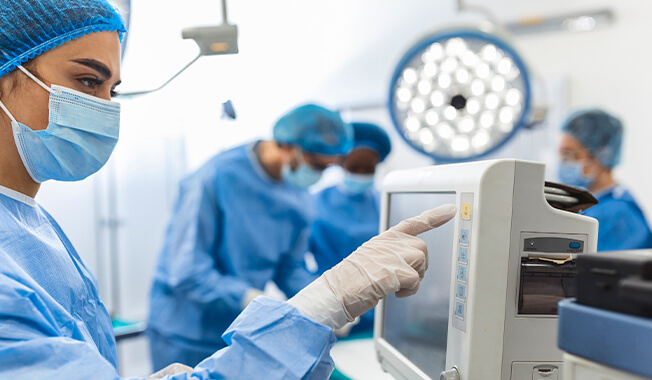 Surgeons working with various medical equipment in a clinical setting. 