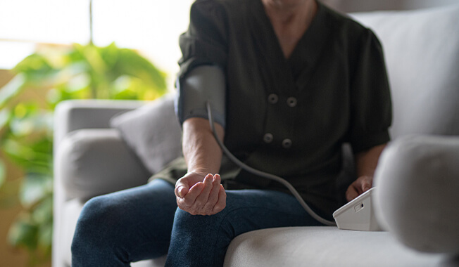 Person checking their blood pressure with an automatic monitor.