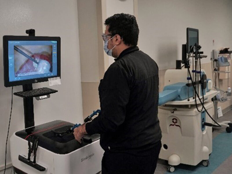 A man in black clothes standing and using a screen based simulator.