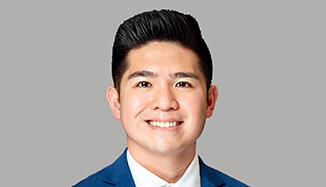 A man in a blue suit smiling at the camera.