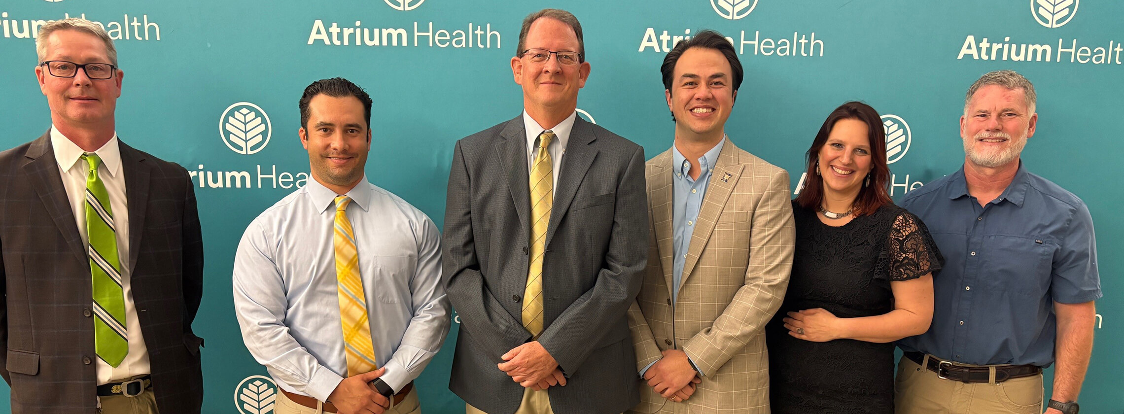 Cabarrus Sports Medicine faculty and staff standing together in suits and business casual attire.