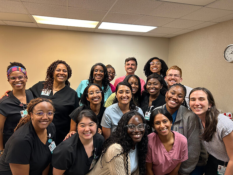 A large group of men and women gathered together in a room for a photo.