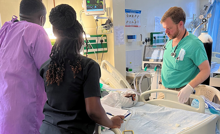 Medical professionals around a medical bed.
