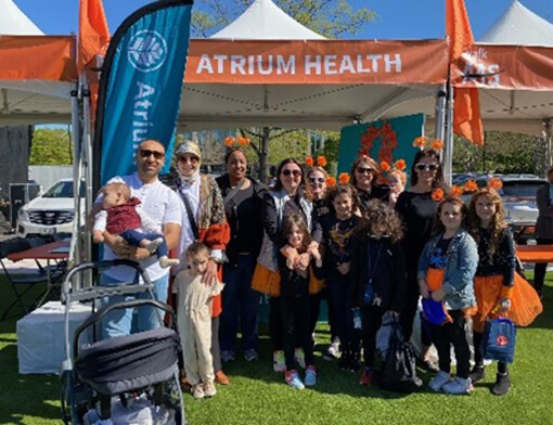 Residents standing together in a group under an orange banner that says "Atrium Health".