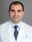 A headshot of a man wearing a lab coat.