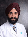 A medical professional wearing a lab coat and smiling at the camera.