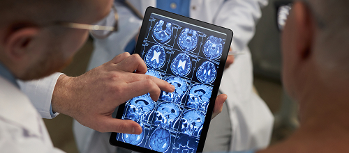 Two people looking at imaging on a tablet screen.