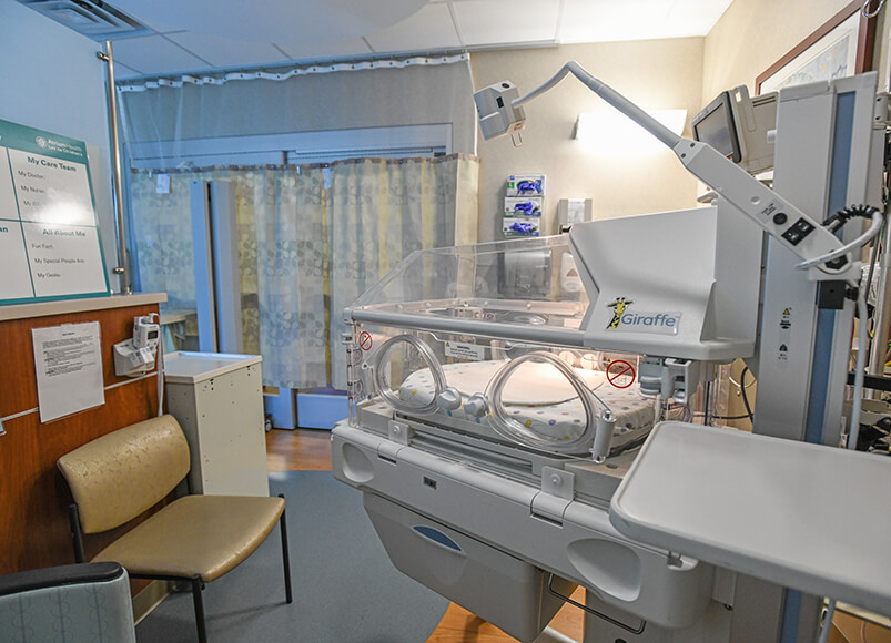 A NICU room complete with seating plus medical and monitoring equipment.