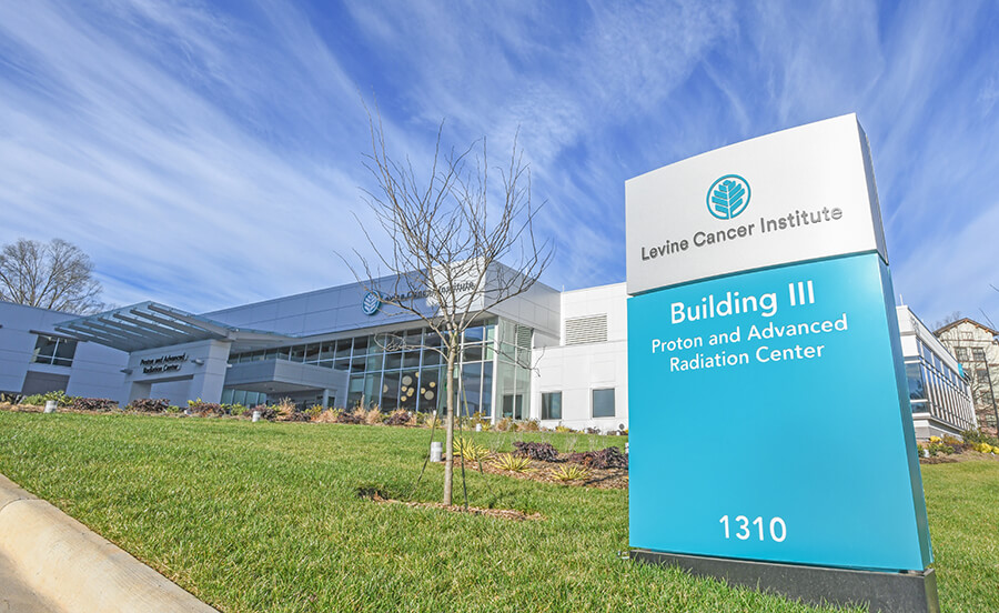 An exterior sign that reads "Levine Cancer Institute Building III Proton and Advanced Radiation Center".