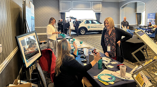 Two women speaking to each other at a conference.
