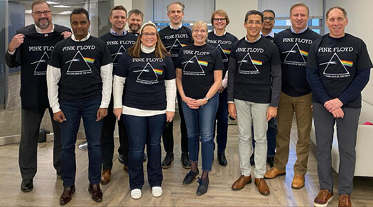 A group of people standing in a row and smiling at the camera.