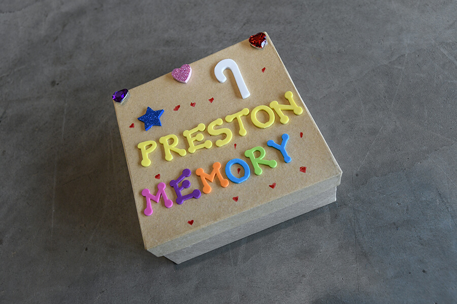 A wooden box with decorations that read "7 Preston Memory".