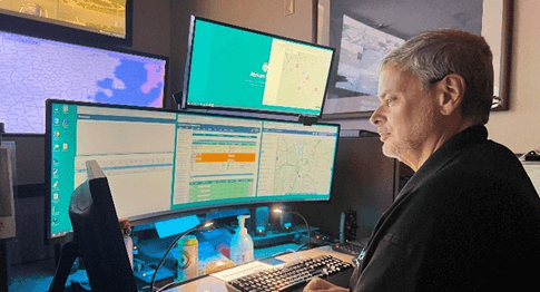 Man looking at screens in communications center