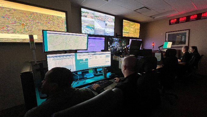 People facing screens in control room of communications center for Med Center Air