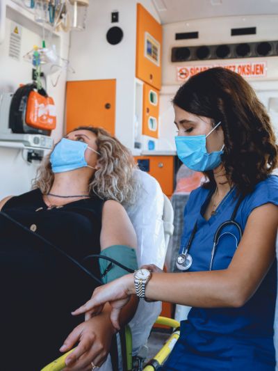 Female EMT taking care of female patient inside ambulance