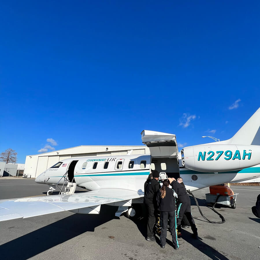 Medical team putting medical equipment inside Pilatus PC-24 Med Center Airplane door