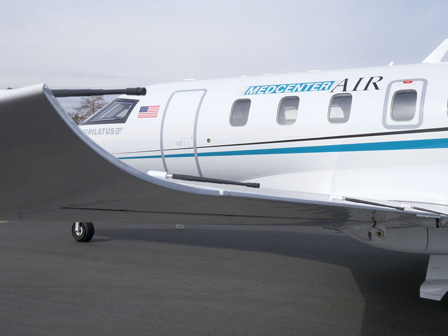 A side view of a fixed-wing plane with the words "MedCenter Air" on the side of it.
