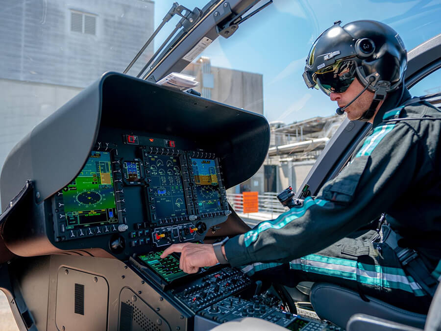 A pilot in a flight suit piloting a helicopter.