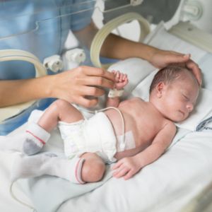 Photo of baby in intensive care being checked by nurse