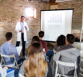 Man giving presentation to women and men about digestive health.