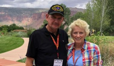 Photo of Kim Roberts on left wearing black shirt, lanyard and baseball camp and Kay Roberts, wearing blue and red plaid shirt overlooking nature.