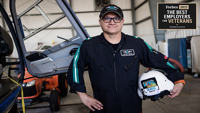 Atrium Health veteran in front of a helicopter