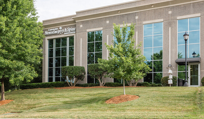 An exterior view of a medical office building with a sign that reads Carolina NeuroSurgery & Spine Associates.