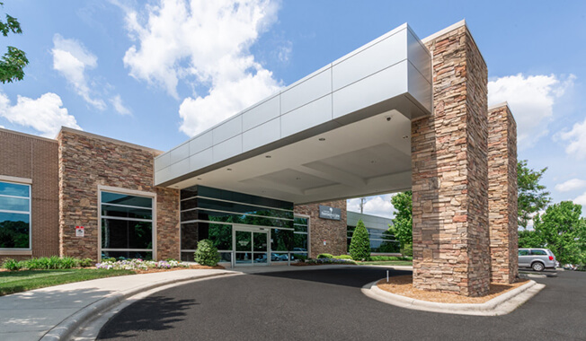 An exterior view of a medical building with a drop-off point.
