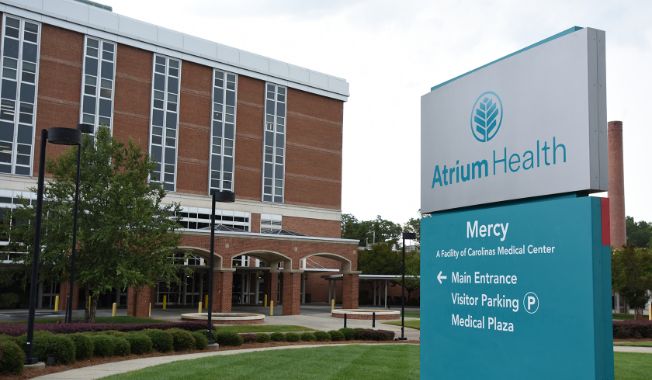An exterior of a medical office, with a teal and white sign that reads Atrium Health Mercy.