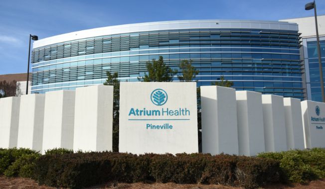 An exterior picture of a medical office, with large white columns - one reads Atrium Health Pineville.