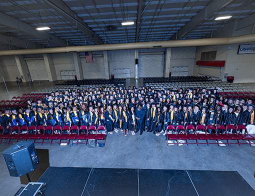 2026 graduates standing in a large group while wearing their caps and gowns.