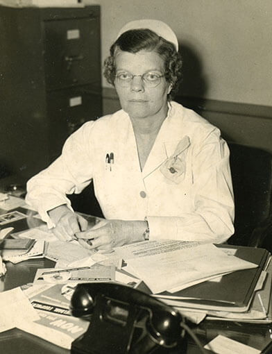 Louise Harkey sitting at a desk.