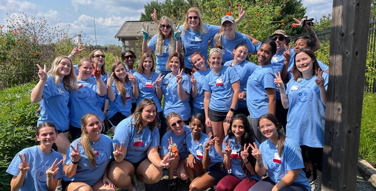 All of the volunteers in blue t-shirts posing for a group photo at the Healing Garden.