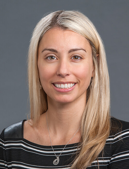 A woman with long blonde hair smiling at the camera.