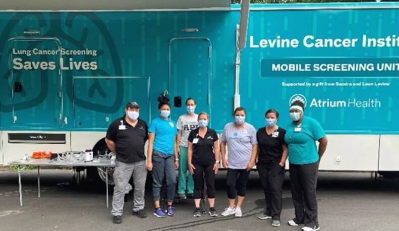 A group of men and women standing together in a room.