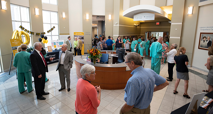 A variety of employees, donors and community members mingle in the atrium of the Lexington Medical Center during the ribbon-cutting for the new surgical suite