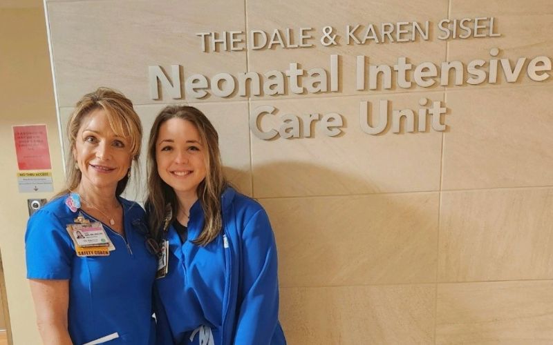 Lori and Ellie, mother and daughter in front of The Dale & Karen Steel Neonatal Intensive Care Unit.