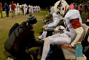 Football player being cared for by an Athletic Trainer
