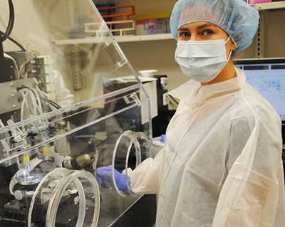 2017 Summer Scholar participant Amelia Hurley-Novatny, University of Maryland, in lab wearing hair net, mask and jacket
