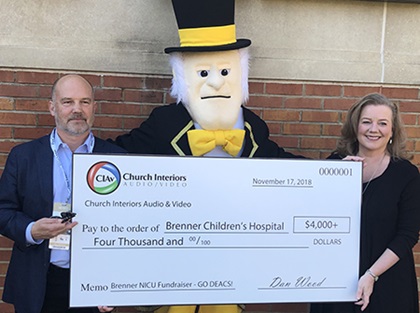 Dan Wood with Church Interiors presents Dr. Cherrie Welch, medical director of the NICU, with check
