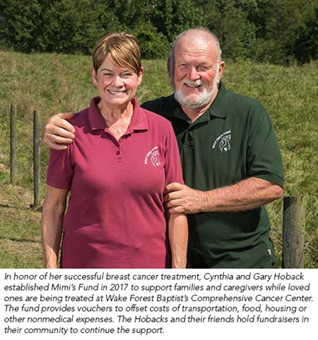 Cynthia and Greg Hoback stand in a green field at their home