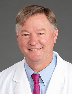 Head shot of older white man wearing white coat