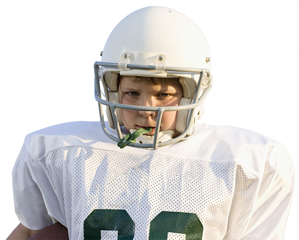 White child in green and white football uniform and helmet scowls